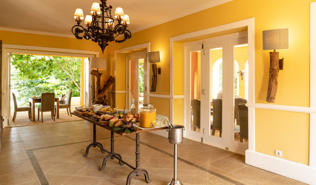 Pequeno-almoço buffet na sala de jantar amarela do Belo Monte, candelabro aceso e portas abertas para os jardins.