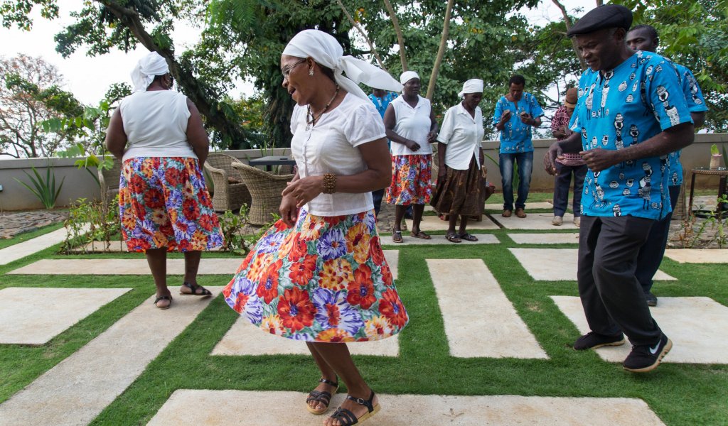 Pessoas da Ilha de São Tomé e Príncipe com trajes tradicionais a dançar em público