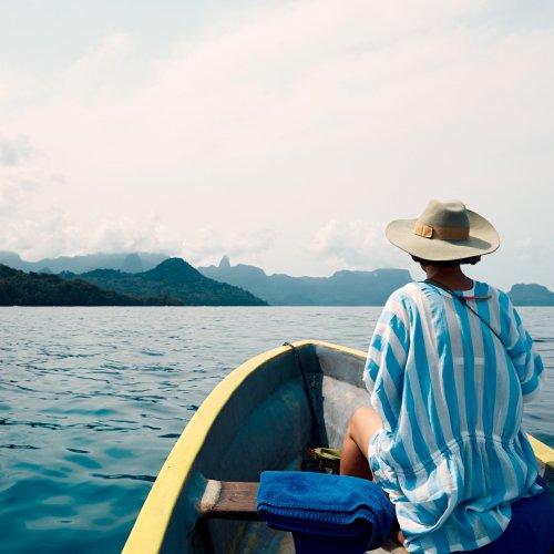 Woman on a small boat facing forward toward Príncipe Island