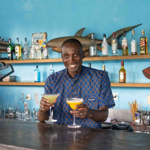 Bartender serving two tropical cocktails at the bar of Omali, São Tomé Island