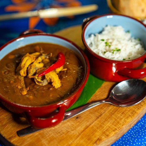 Traditional São Tomé stew with rice and red chilli served on a wooden board at the Omali restaurant, São Tomé Island