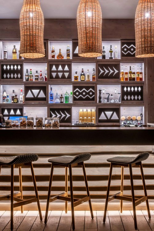 Um bar de bebidas com garrafas em prateleiras at Sundy Praia