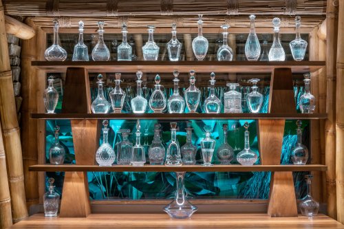 Garrafas vazias em prateleira de madeira atrás do bar at Sundy Praia