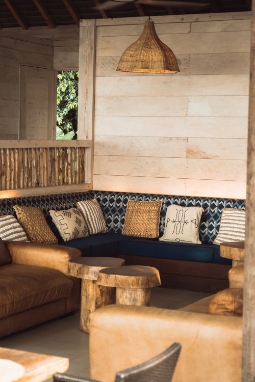 Cozy lounge corner with leather sofas, woven cushions and wooden tables at Bom Bom Beach Club