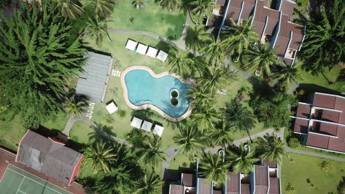 Vista aérea do Omali com vegetação exuberante e piscina ao ar livre