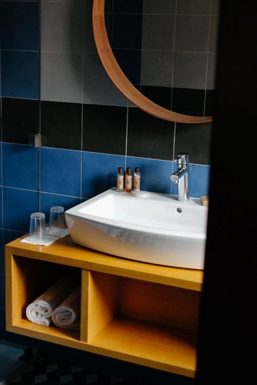 Bathroom with wooden cupboard and white sink at Omali