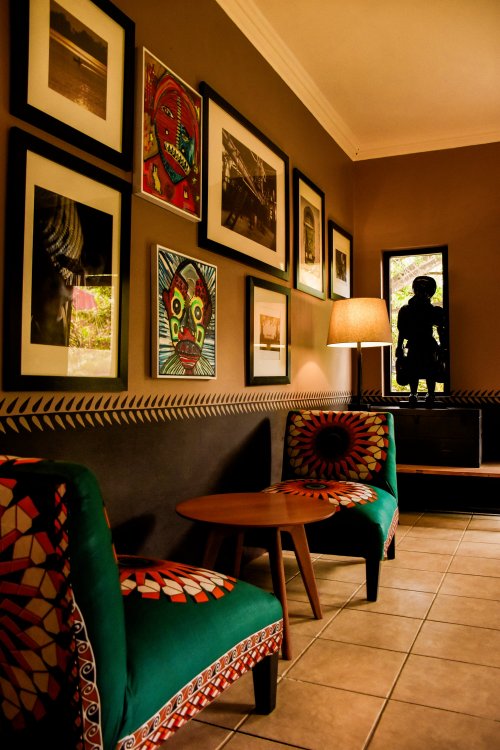 Lobby at Omali with elegant decor and framed photos on the wall.