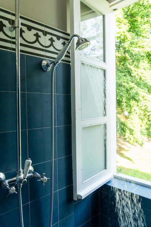 Shower in the bathroom at Roça Sundy suite with an open window