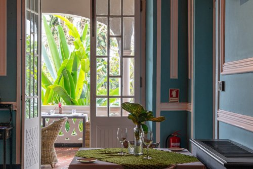 Charming room at Roça Sundy with a view of the lush garden