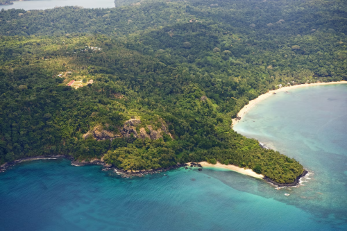 Aerial coastline near Belo Monte on Príncipe Island, rainforest headland, sandy bays and turquoise water.