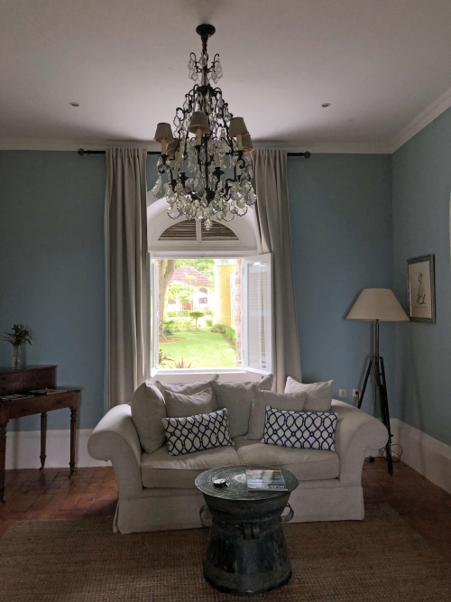 Cosy sitting room in the Panoramic Suite at Belo Monte, blue walls, chandelier and window overlooking the courtyard.