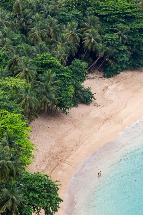 Vista aérea da Praia Banana perto do Hotel Belo Monte, dois hóspedes nas águas turquesa para um mergulho calmo