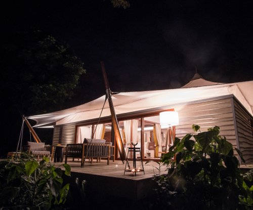 An internally lit villa with terrace at night at Sundy Praia