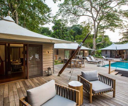 Terrace of the Sundy Praia 3-bedroom pool villa with pool in the background and seating area in the foreground.