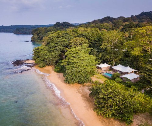 Aerial view of the 3-bedroom pool villa at Sundy Praia, with the beach in the foreground and rainforest in the background.