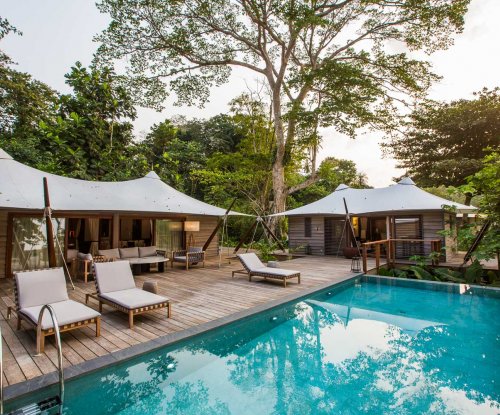 Pool with three loungers and in the background the three bedroom villa at Sundy Praia