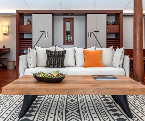 Living room with coffee table in the foreground, couch behind, all on carpet at Sundy Praia
