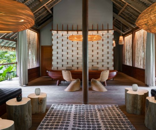 Reception with small wooden tables, large hanging lamps, and carpet at Sundy Praia