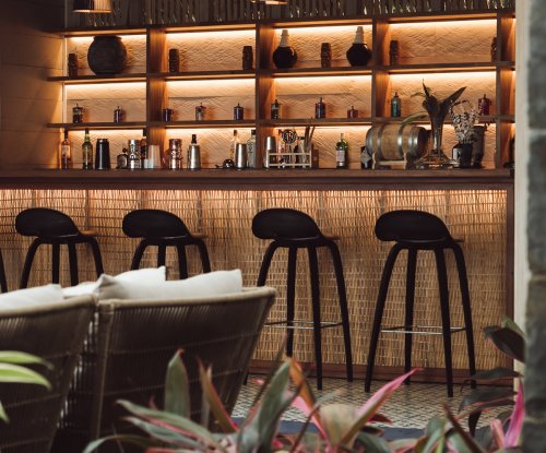 Close-up of bar with stools and illuminated shelving at Bom Bom Beach Club