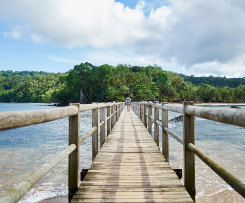 Ponte de cais com homem a caminhar para o Bom Bom