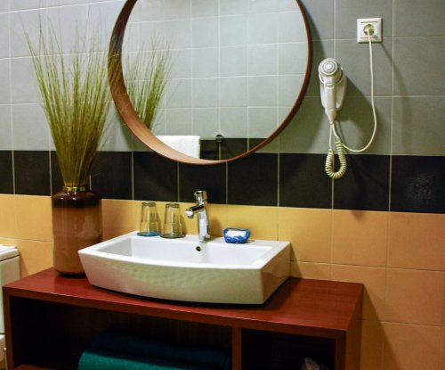 Bathroom with a white sink and mirror at Omali.