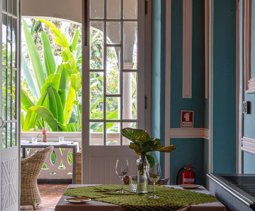 Charming room at Roça Sundy with a view of the lush garden
