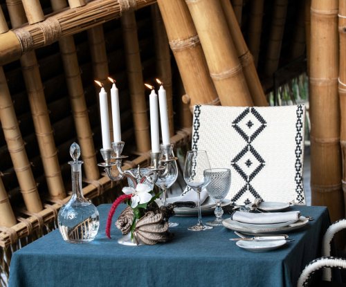 Uma mesa posta com toalha azul no restaurante Oka Sundy