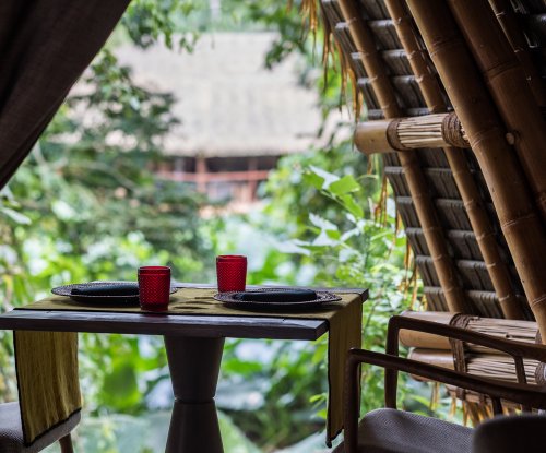 Vista interior do restaurante OKA Sundy com uma mesa de jantar