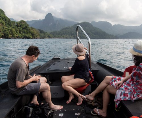 Três turistas a navegar num barco em direção à Baía das Agulhas