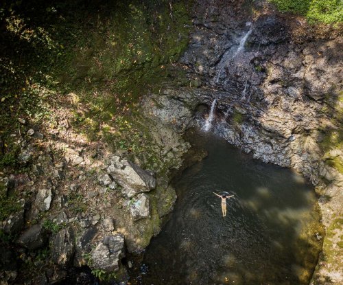 Vista aérea de uma pessoa a flutuar nas águas da Cascata Oque Pipi