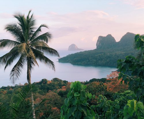 Panoramic view of Príncipe Island with lush forest and a beach in the background