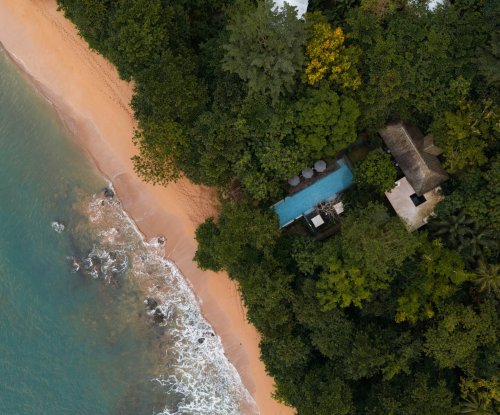 Vista aérea da praia do Sundy Praia e da piscina no meio da floresta na Ilha do Príncipe, a poucos passos do mar