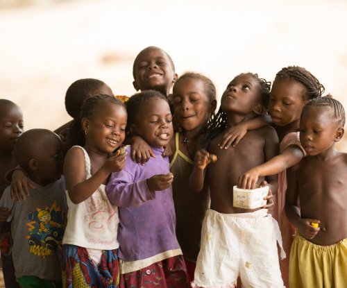 Group of local children laughing and embracing, Príncipe Island