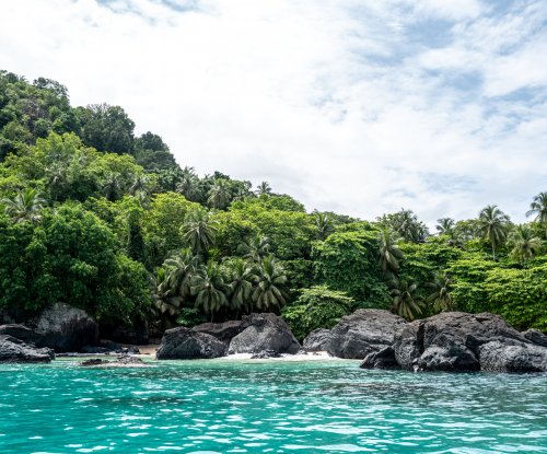 Praia isolada com rochas vulcânicas escuras e águas turquesa, Ilha do Príncipe