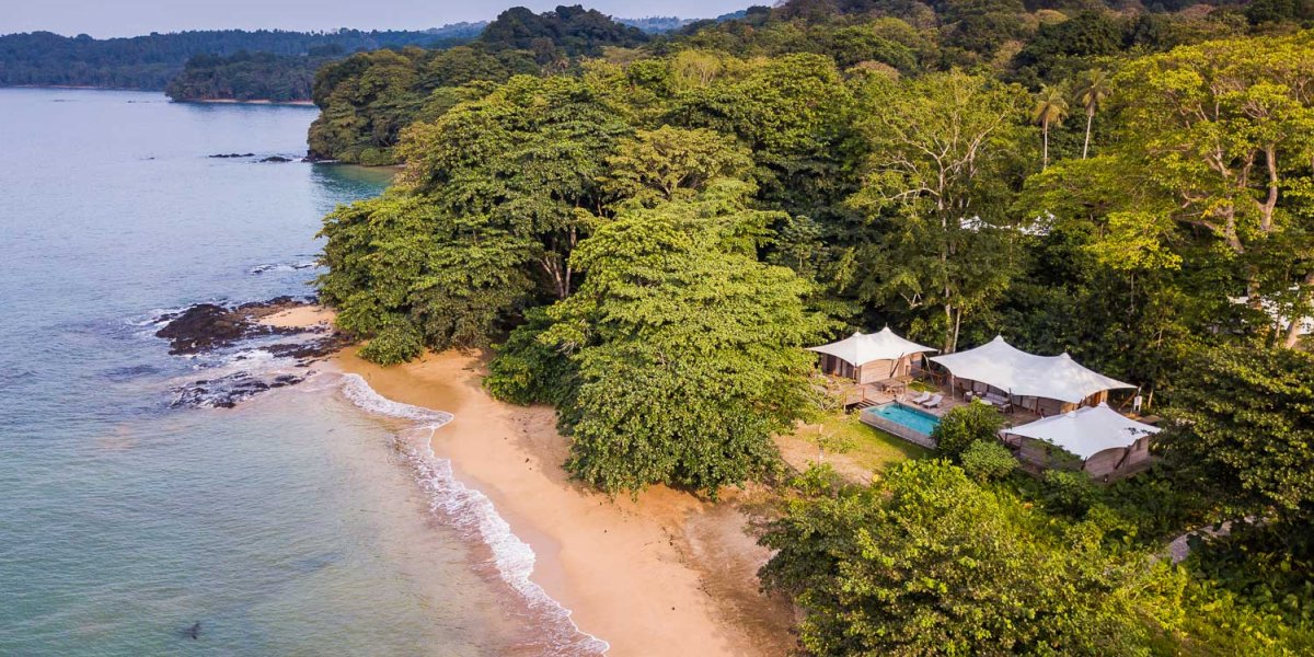 Aerial view of the 3-bedroom pool villa at Sundy Praia, with the beach in the foreground and rainforest in the background.