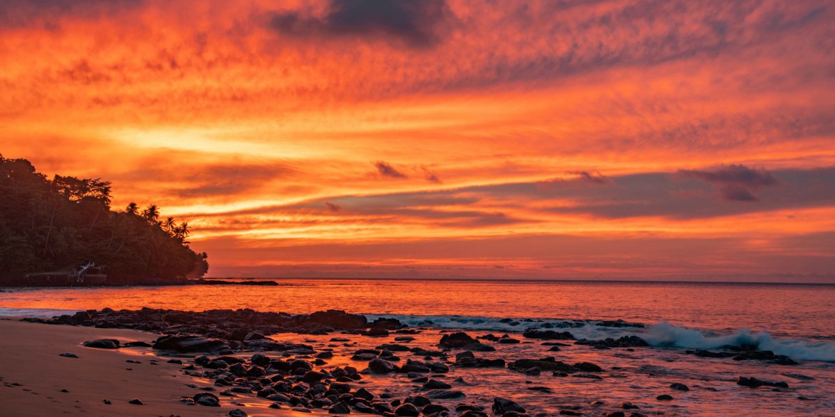 Orange-colored evening sky at sunset with beach and sea view at Sundy Praia
