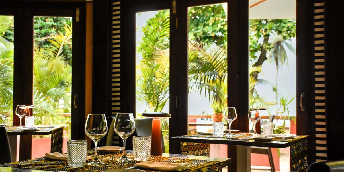 Dining area with tables, chairs, and umbrellas at Omali Restaurant, São Tomé