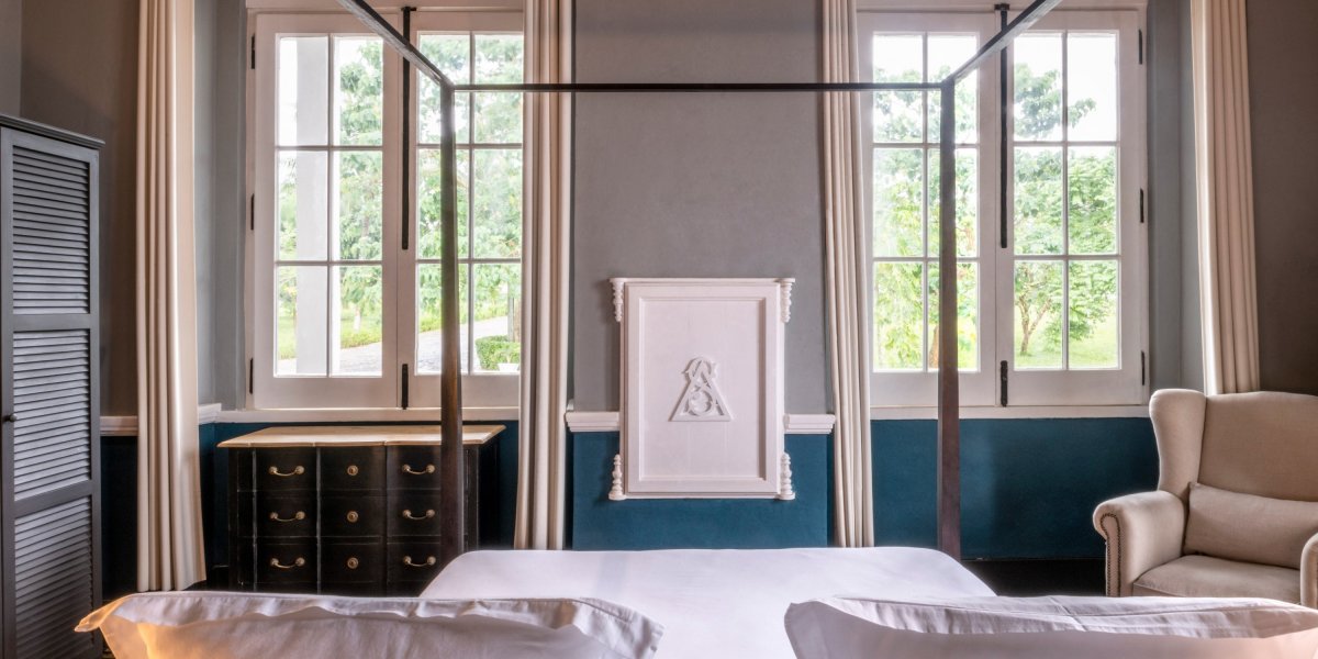 Suite iluminada na Eclipse House na Roça Sundy com cama dossel e vista para o jardim