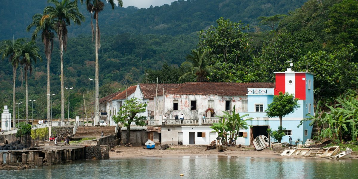 Santo António harbour with colonial buildings and a red and white lighthouse, Príncipe Island