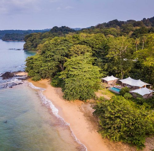 Aerial view of the 3-bedroom pool villa at Sundy Praia, with the beach in the foreground and rainforest in the background.