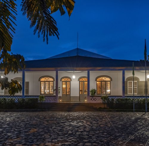 Exterior view of the illuminated Eclipse House at Roça Sundy at night