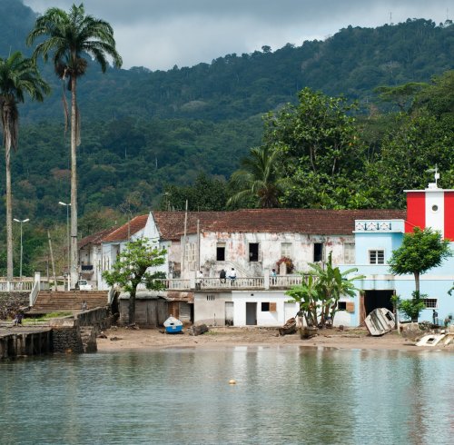 Santo António harbour with colonial buildings and a red and white lighthouse, Príncipe Island