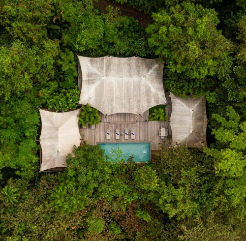 Vista aérea da Pool Villa de Sundy Praia com piscina privada e deck em madeira, integrada na floresta tropical, Ilha do Príncipe
