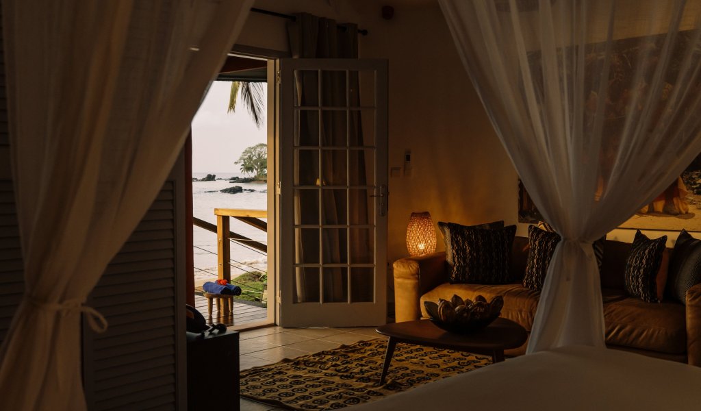 Beach bungalow with a four-poster bed at Bom Bom Beach Resort.