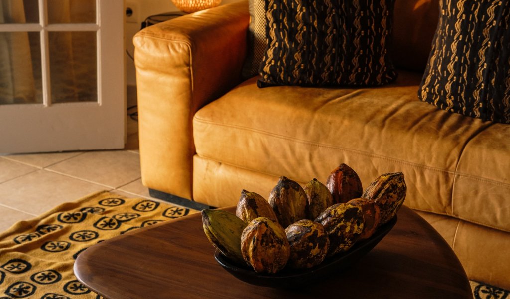 Living area with a couch and African art in a beach bungalow at Bom Bom Beach Resort.