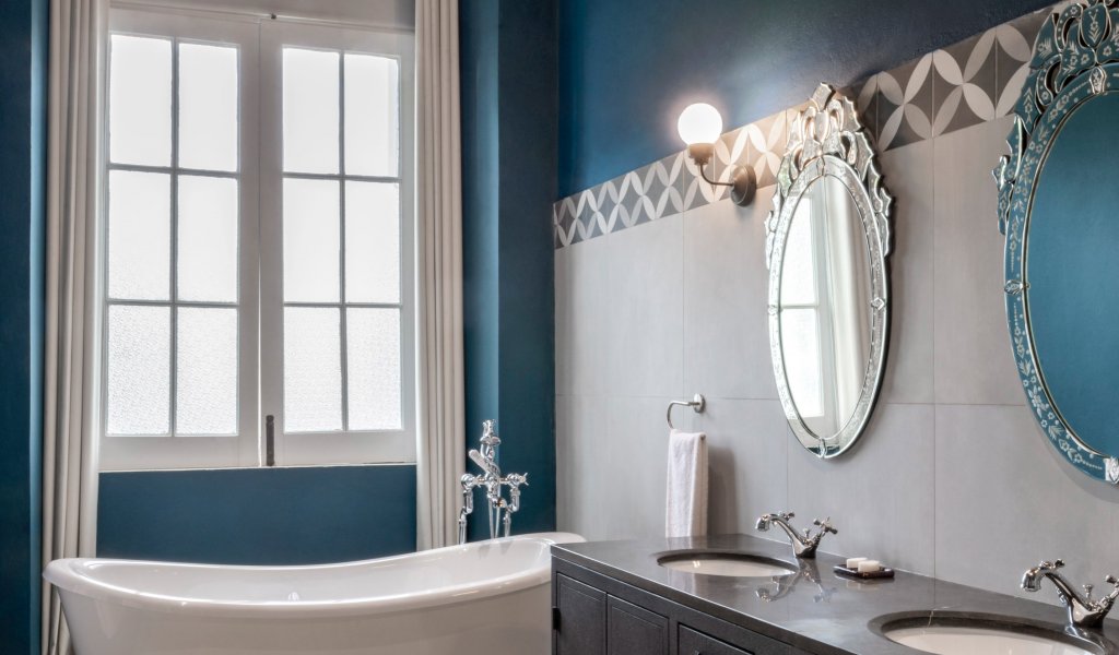 Elegant bathroom at Eclipse House in Roça Sundy with bathtub, double sink, and large window